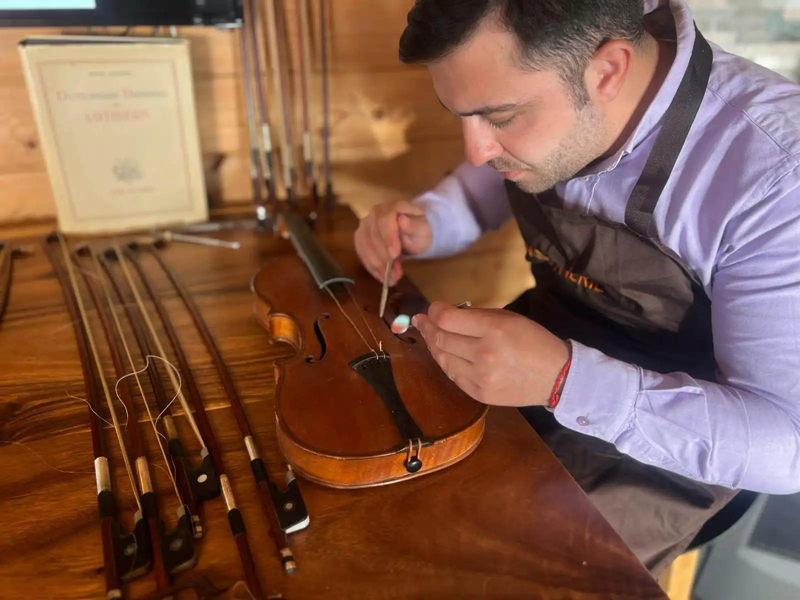 Artisan luthier M. Ziegler en train de réparer un violon